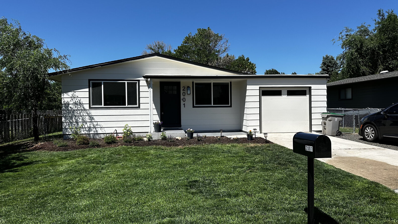 The same house after the flip — white siding, black trim, cleaned up and sold