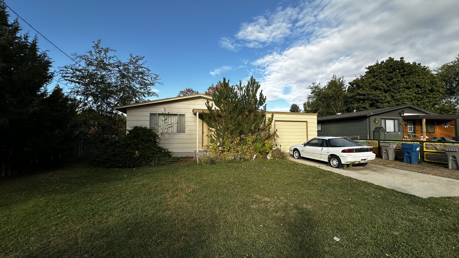 Our first flip before renovations — dated exterior, overgrown landscaping
